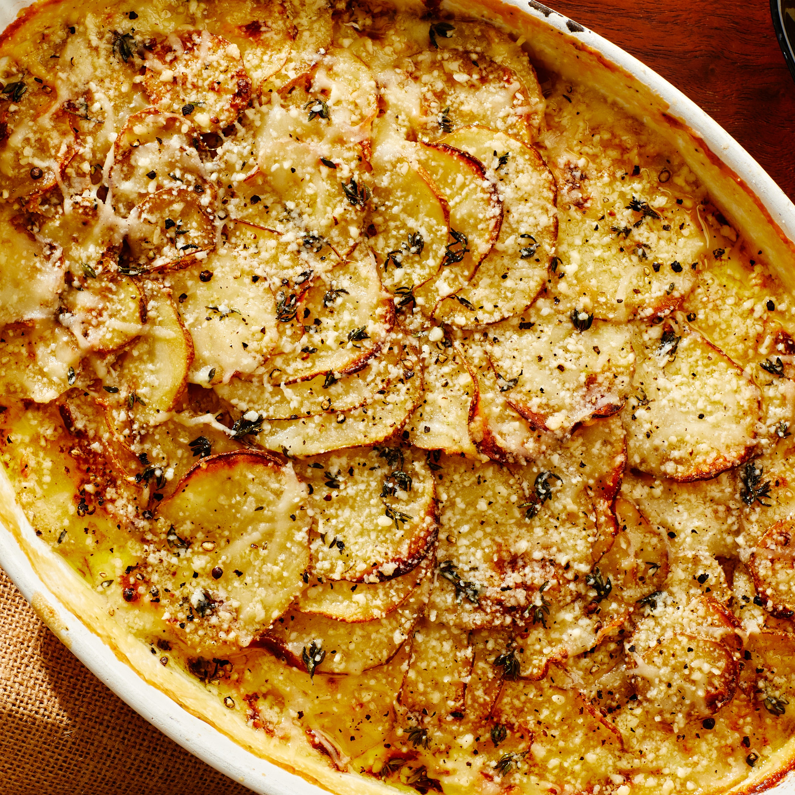 Potato gratin in a casserole dish on a wood surface
